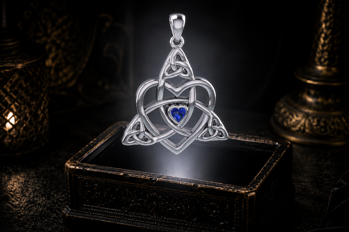 Heart-shaped sapphire centered within sterling silver Celtic Trinity knotwork, hovering above an ornate jewelry box in atmospheric lighting