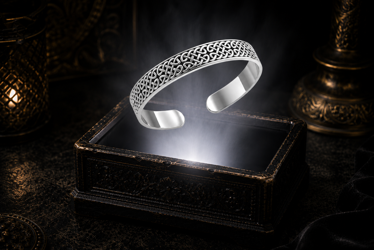 Sterling silver Celtic knot cuff bracelet floating above an ornate jewelry box illuminated by soft white light in a dark luxury setting with intricate Celtic knotwork, cinematic atmosphere, and refined heritage-inspired elegance.
