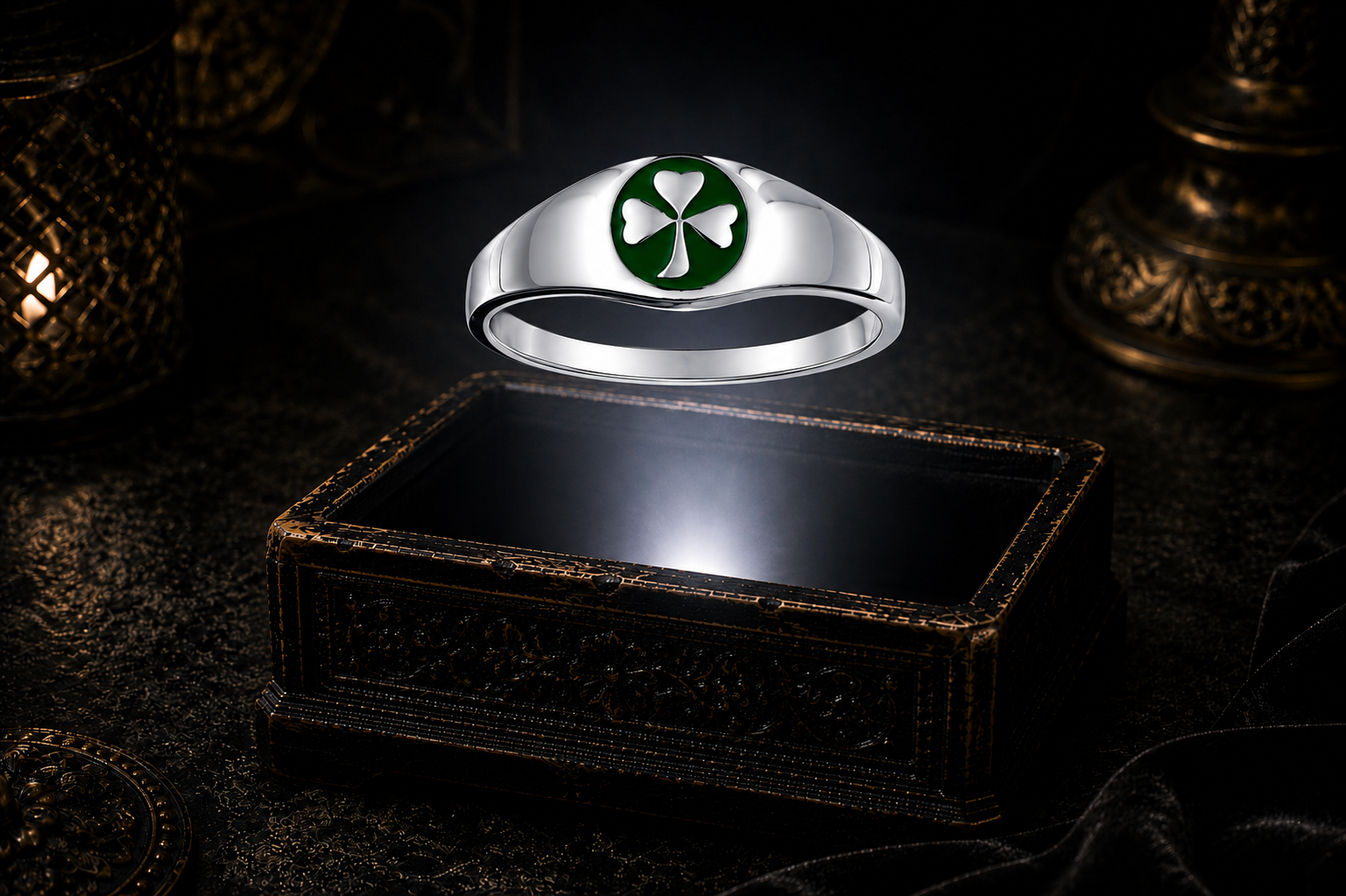Sterling silver Celtic shamrock signet ring with green enamel displayed above an ornate dark jewelry box in a mystical gothic setting.