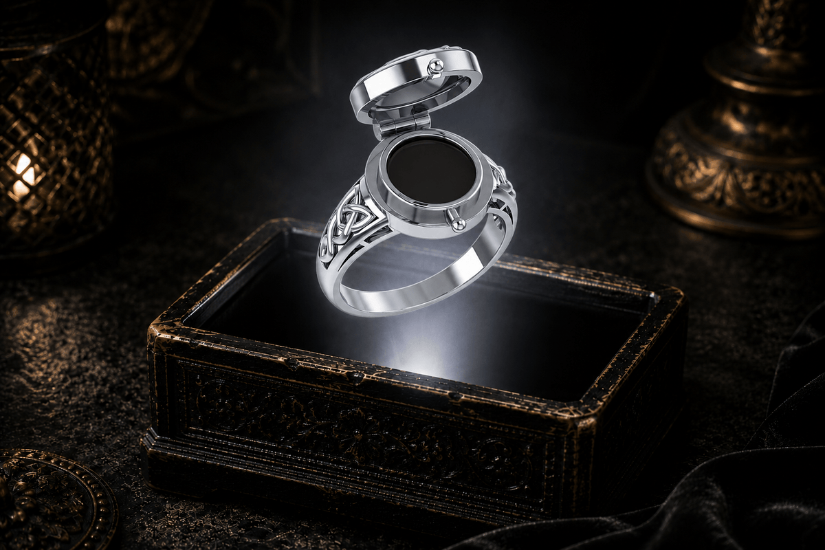 Open Poison Ring in Sterling Silver with Claddagh design showing its concealed compartment and Celtic knotwork band over an ornate keepsake box in a dark cinematic setting
