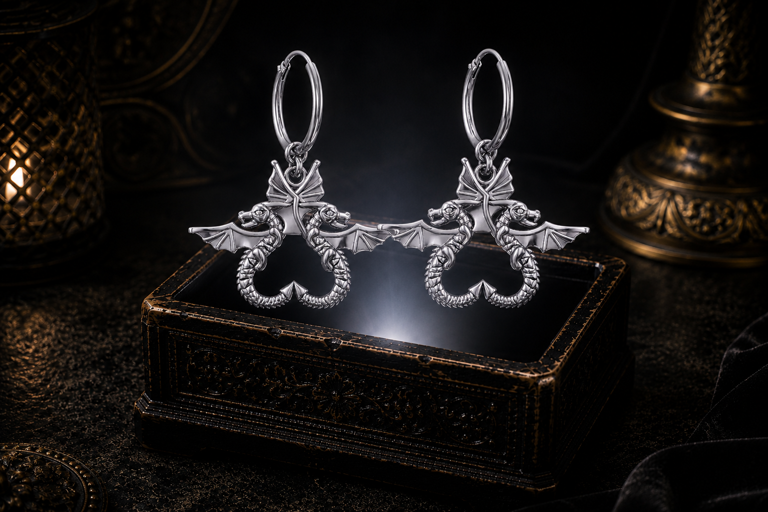 Sterling silver double dragon hoop earrings floating above a glowing ornate jewelry box in a dark luxury setting