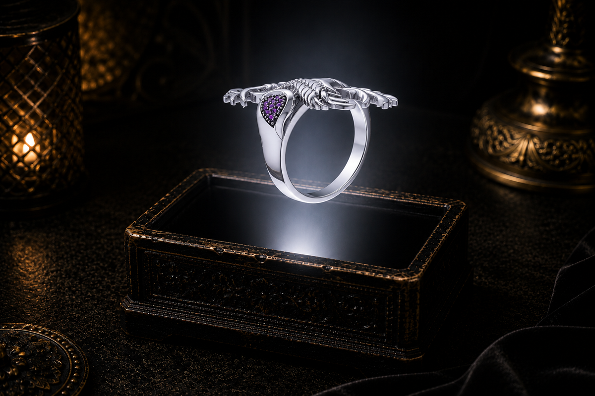 Sterling silver phoenix ring of rebirth with amethyst gemstone accents side-view displayed above an ornate dark jewelry box in a mystical gothic setting.