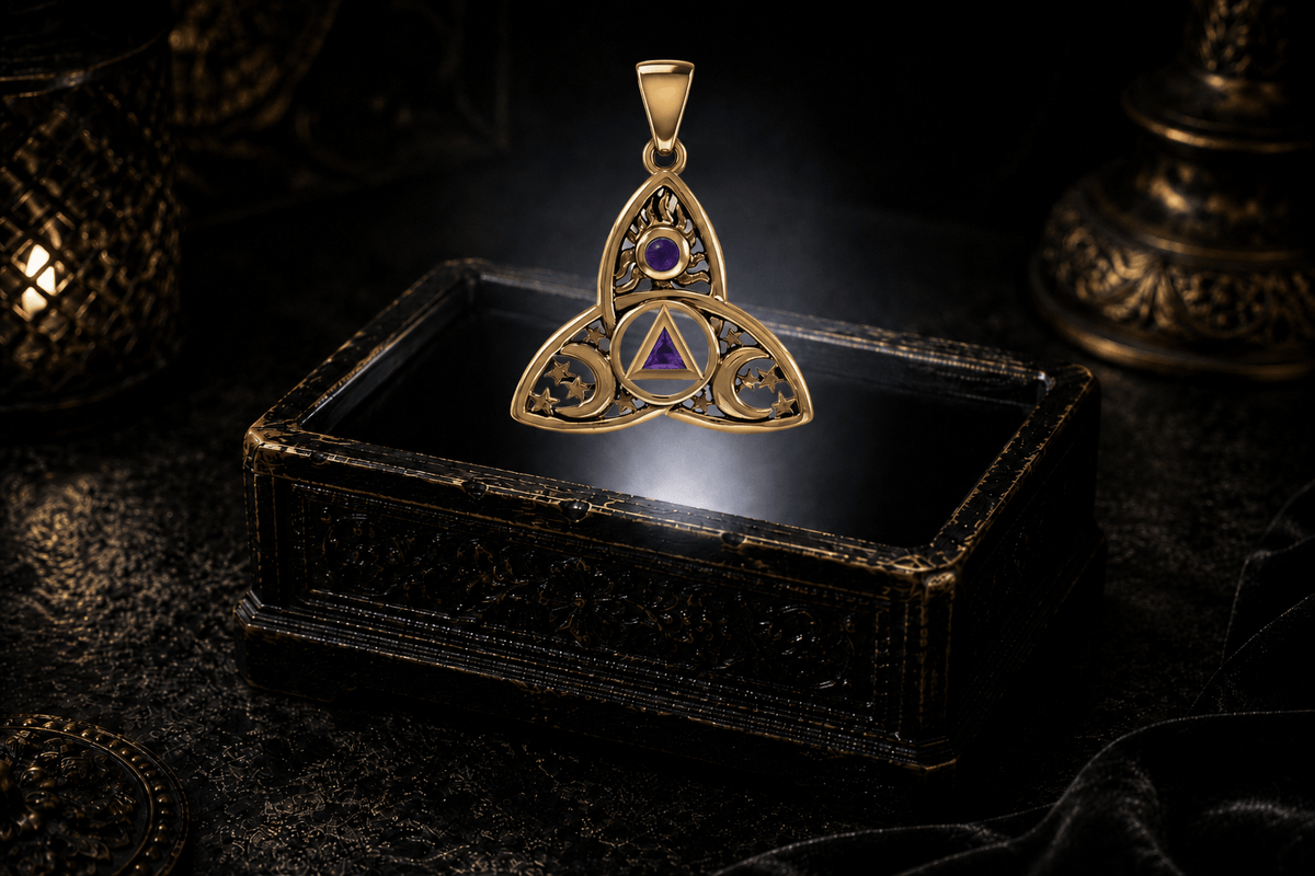 Yellow gold sun, moon and stars Trinity Knot pendant with purple amethyst accents floating above an ornate jewelry box