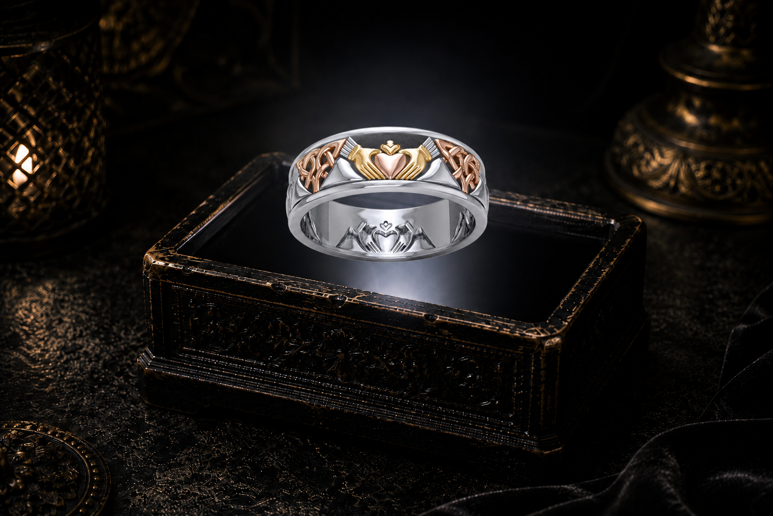 Three-tone Celtic Claddagh sterling silver band ring with gold and rose gole accents hovering above an illuminated antique jewelry box in a dark cinematic mystical luxury setting