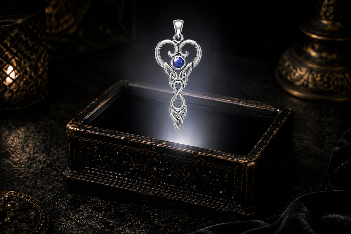 Virgo white gold Celtic pendant with created sapphire suspended above a glowing jewelry box with warm antique accents