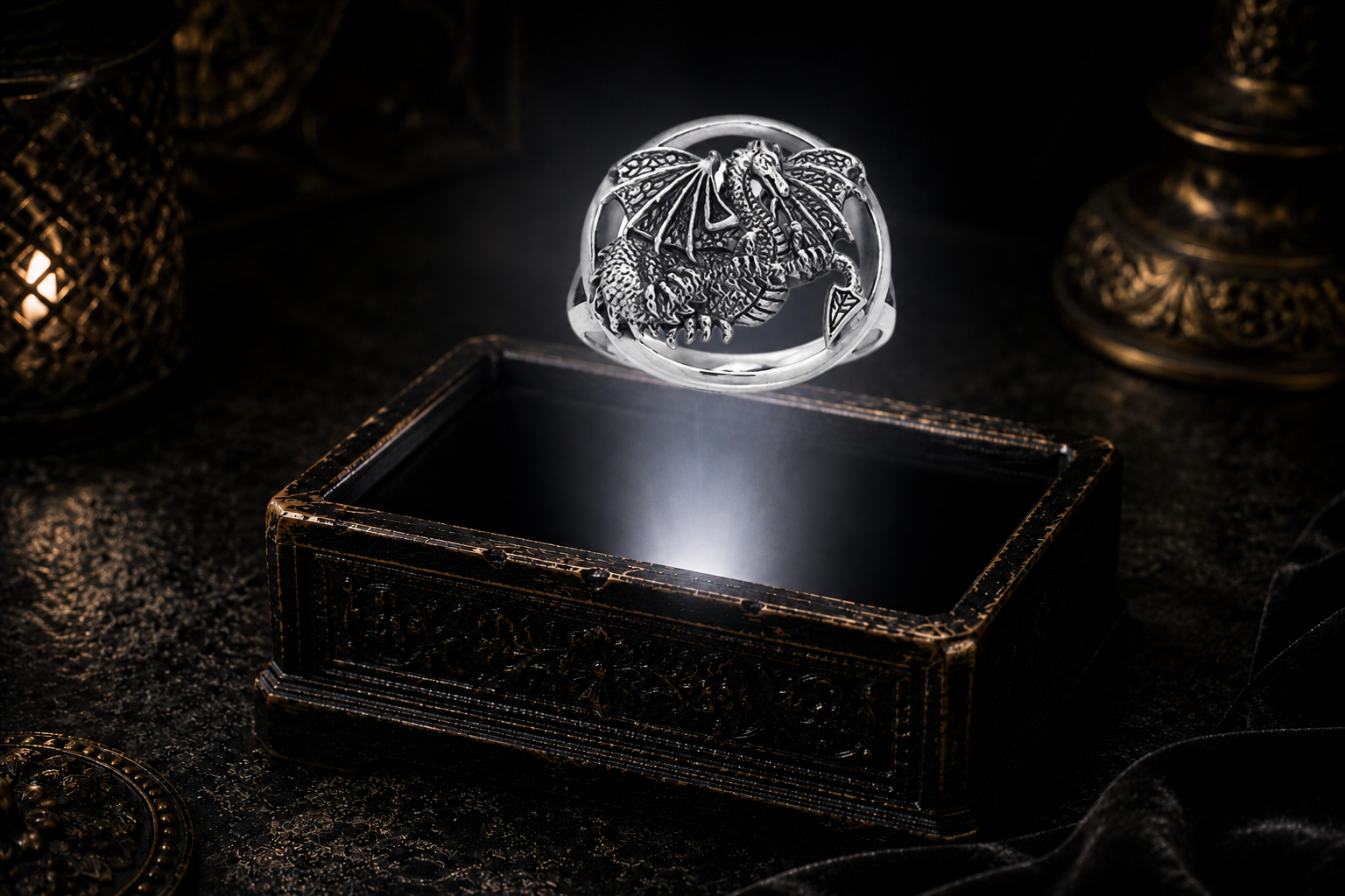 Winged sterling silver dragon ring hovering above an ornate antique jewelry box in a neutral white beam of light.