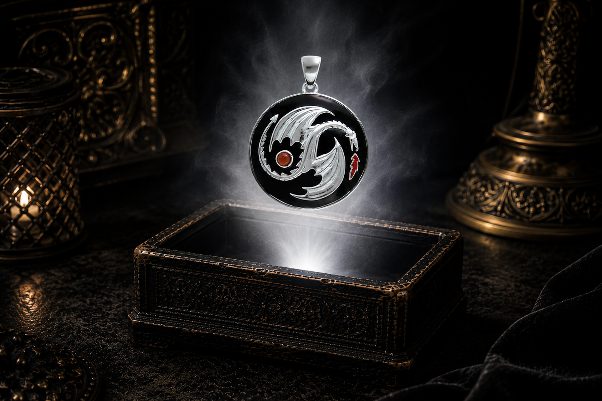 Sterling silver yin yang dragon medallion pendant with black enamel backdrop and red cabochon accent floating above an ornate dark jewelry box surrounded by luminous white light and drifting mist in a cinematic luxury setting.